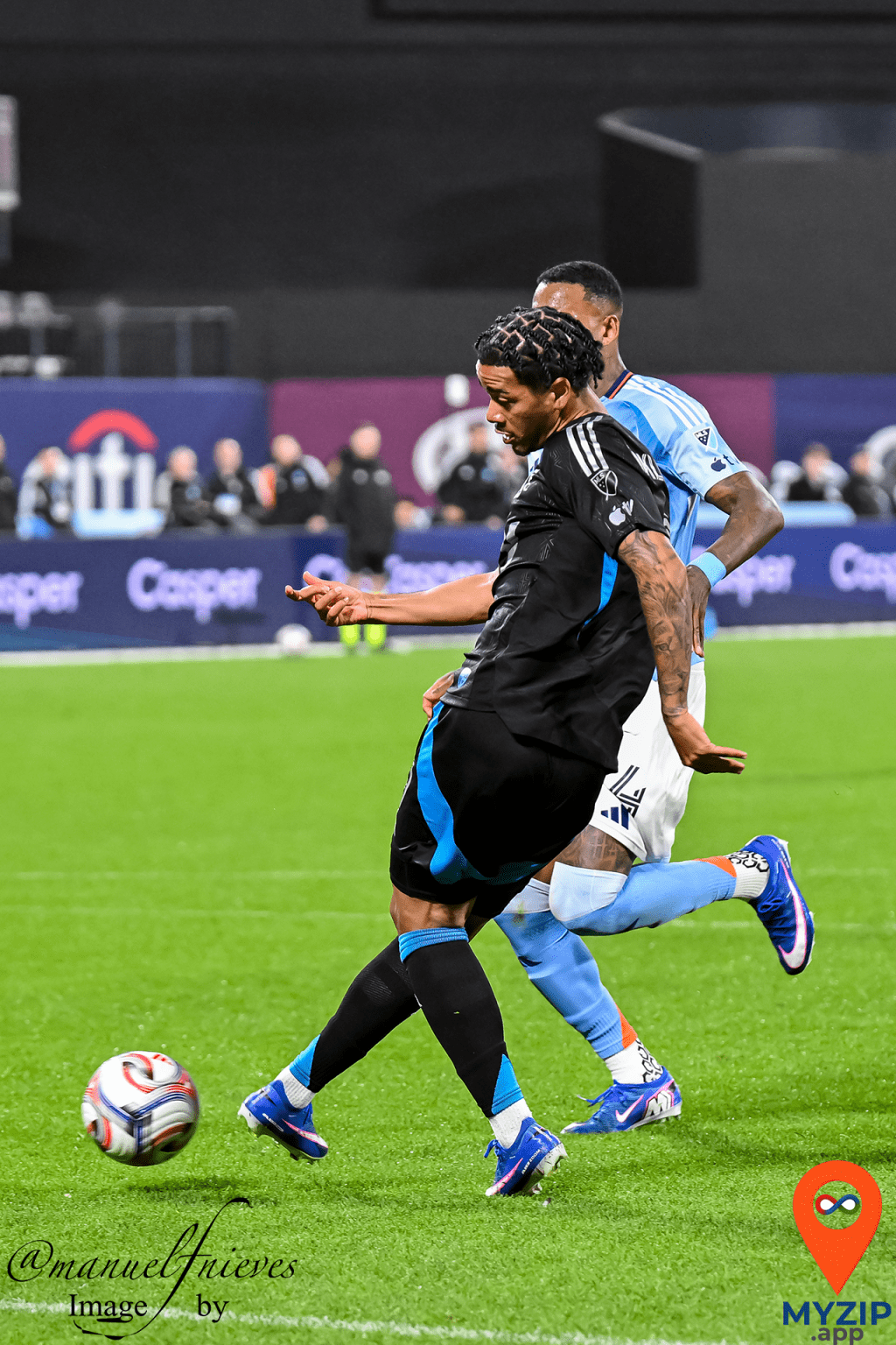 NYCFC player controls the ball under pressure from Charlotte FC defender during MLS match at Citi Field